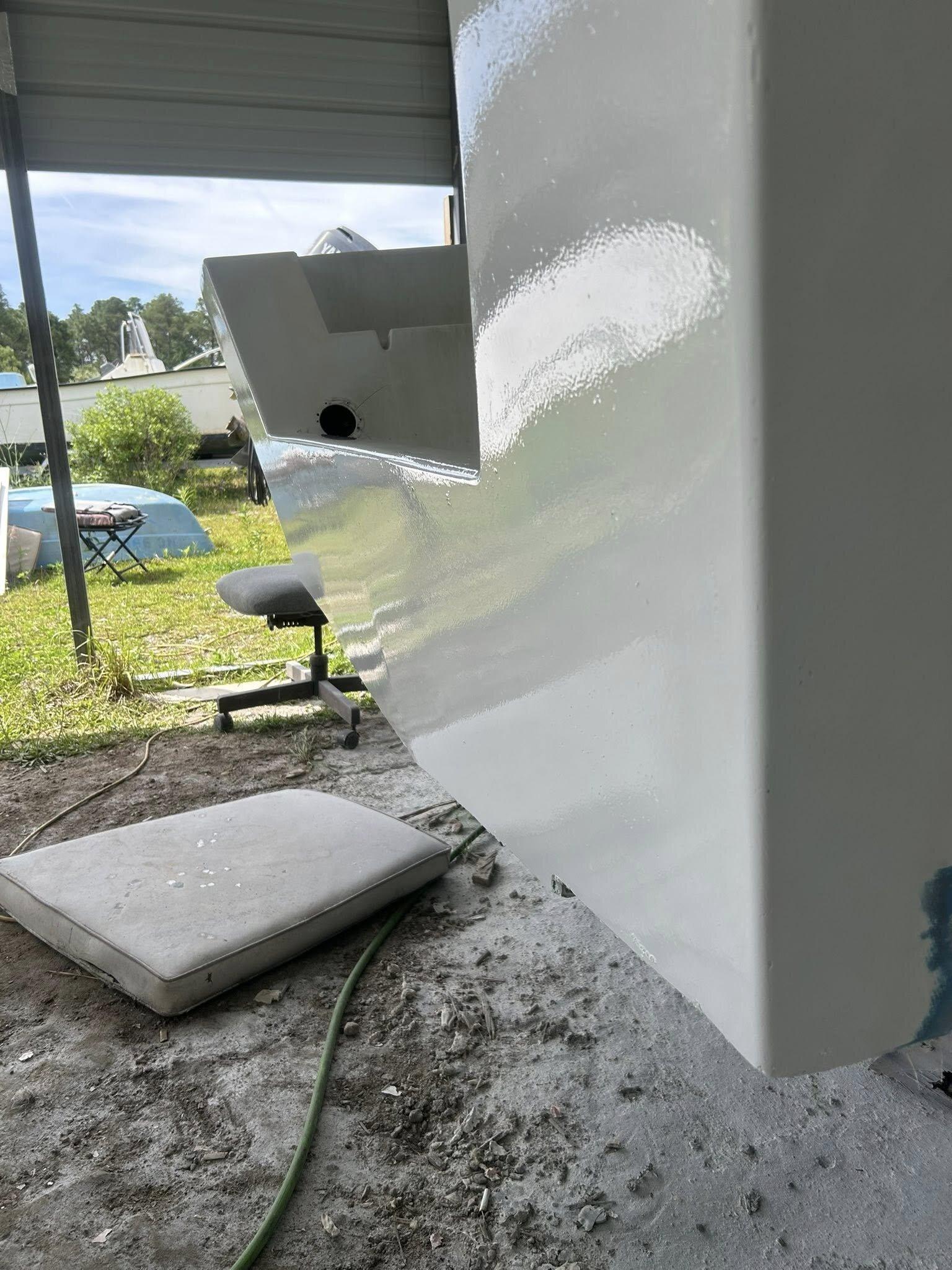 Same transom after structural fiberglass rebuild and fresh white color-matched refinish with glossy finish
